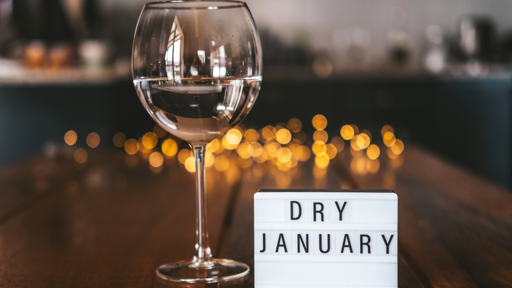 Dry January sign next to a glass of wine.