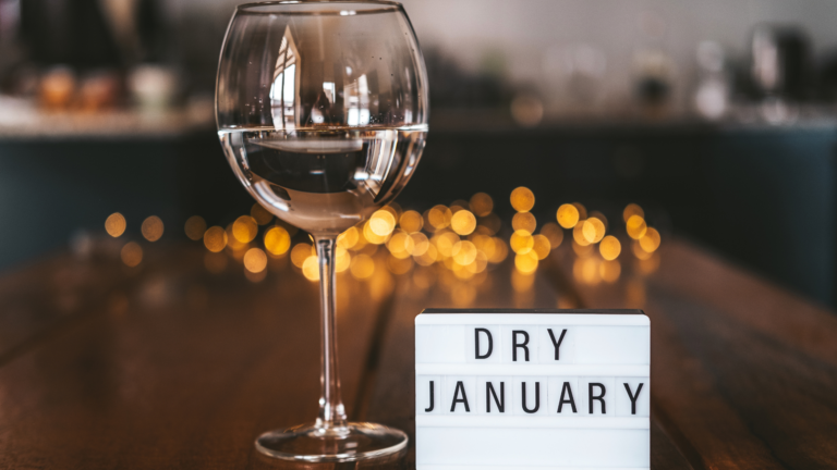 Dry January sign next to a glass of wine.